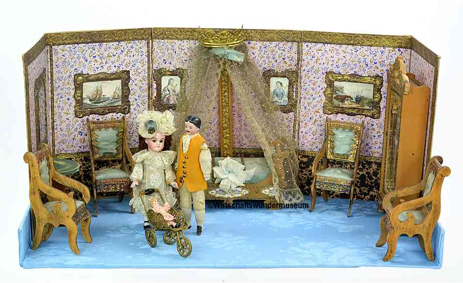 Antike zusammenfaltbare Puppenstube um 1890 mit lithographierter Papprückwand, Himmelbett und zwei feinen Puppen